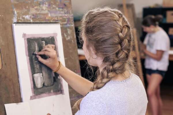 Student using charcoal for a still-life drawing