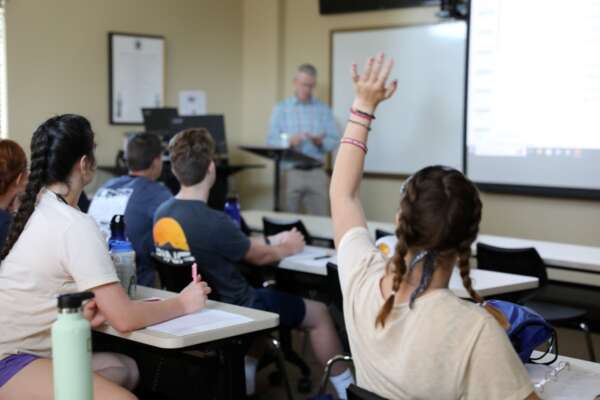 Student raising hand in classroom