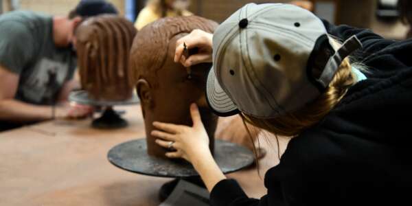 Students sculpting heads