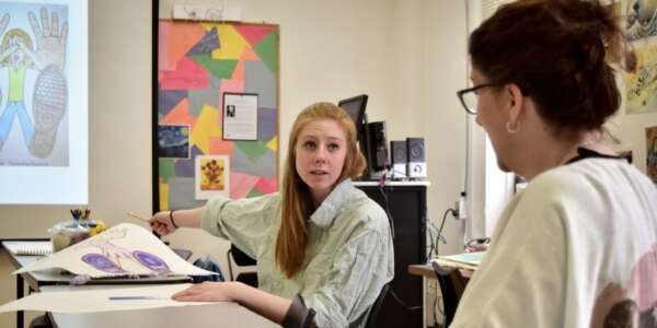 Student and teacher talking about art for children