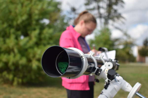 student setting up a telescope