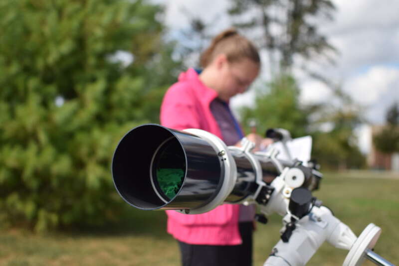 student setting up a telescope
