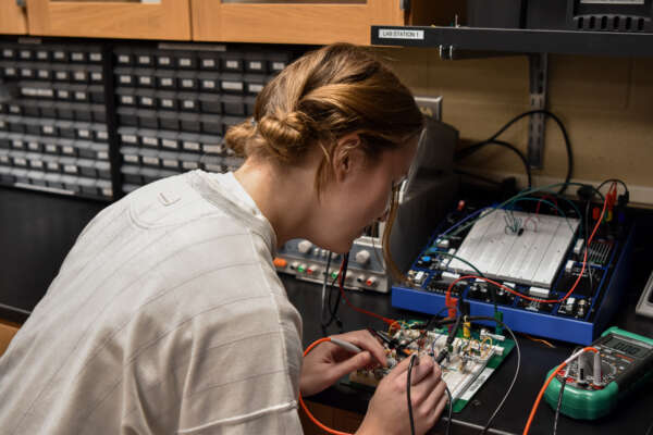 Student working on an electrical circuit board