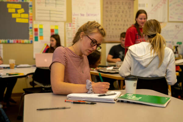Students taking notes in an education classroom