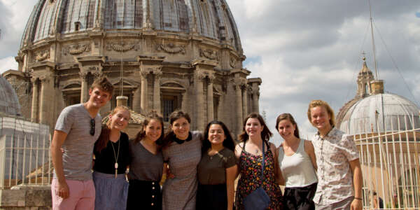 Students pose for a photo in front of a domed building while studying abroad