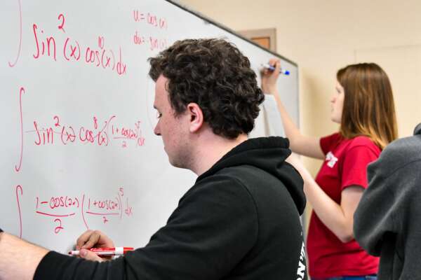 students workng on calculus at a whiteboard