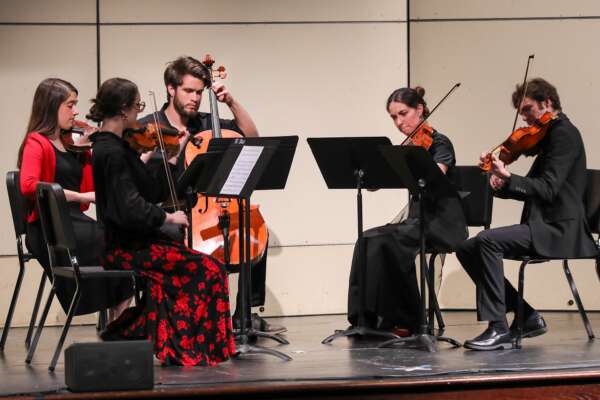 Students performing in a string quintet