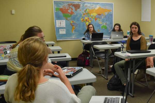 students in a classroom with a map of the world