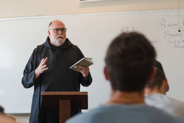 Monk teaching theology at a whiteboard