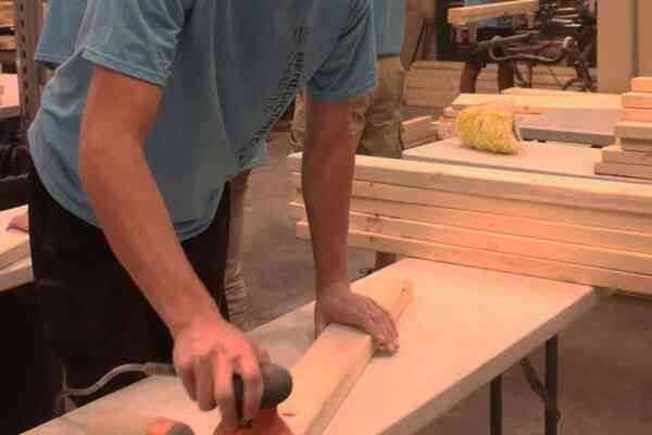 student working with wooden planks