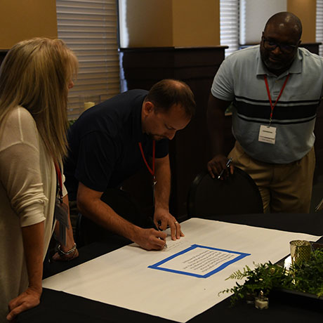 A man writes on a paper during an event