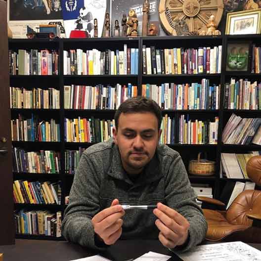 A man holds a pen in an office