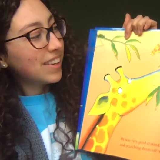 A student holds a book up for the camera