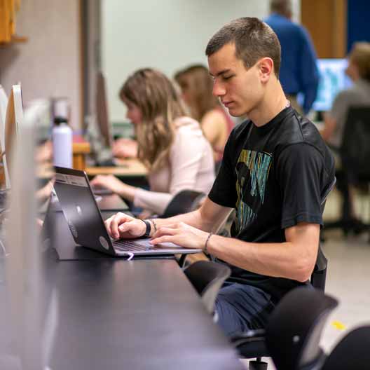 A student works on a laptop in class