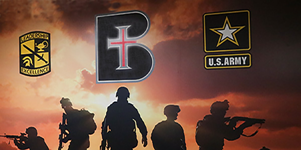 Wall art with silhouettes of five soldiers and the logos of Benedictine College and the U.S. Army