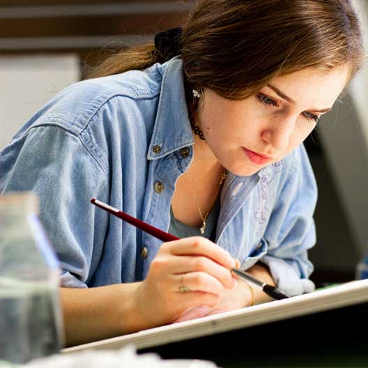 A student at a drafting table in Architecture class