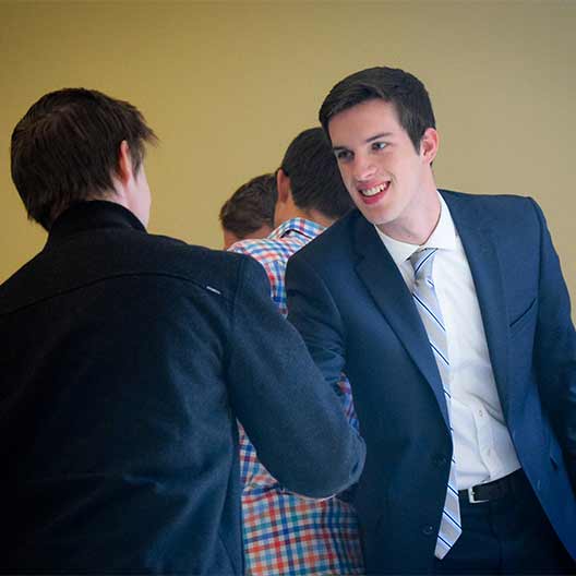 Two business students shaking hands