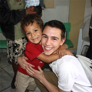 A student embracing a young child