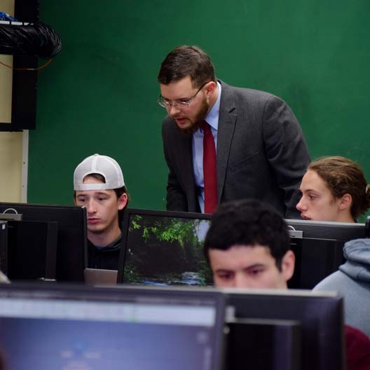 Dr. Charles Sprouse assisting students in Engineering class