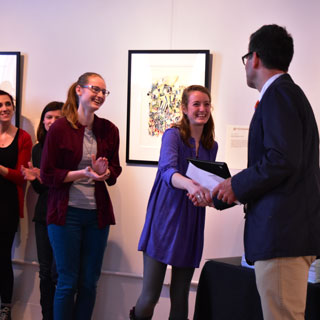 Students shaking hands with a professor