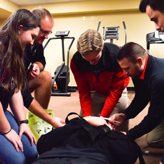 Health, Wellness, and Exercise Science Students practice emergency care, with a fellow student posing on a stretcher