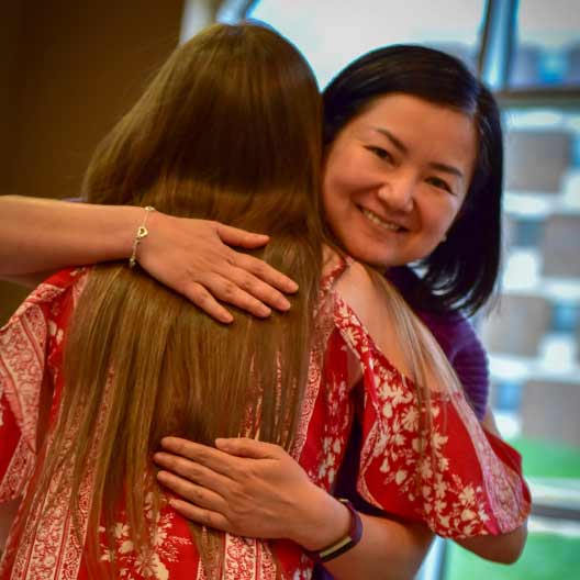 Professor hugging student after giving her an award