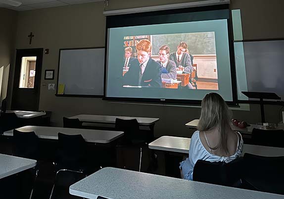 Students watch a movie at a club movie night