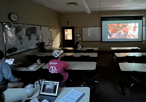 Students watch a movie at a club movie night