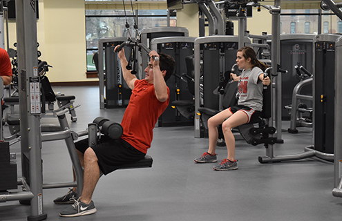 Students using weightlifting machines